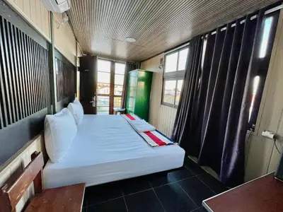 a bedroom with a white bed in a room with windows at trees inn Bali Denpasar in Denpasar