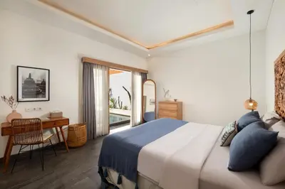 a bedroom with a bed and a desk and a window at Stylish 2BR Villa in Seminyak with Private Pool in Seminyak