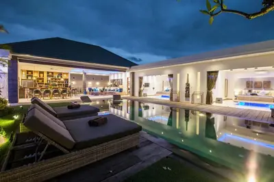a villa with a swimming pool at night at Spacious 4 BR villa Seminyak garden and pool in Seminyak