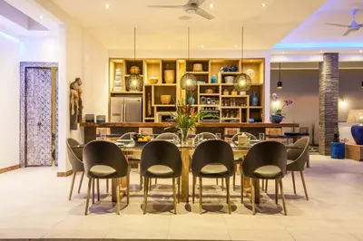 a dining room with a table and chairs at Spacious 4 BR villa Seminyak garden and pool in Seminyak