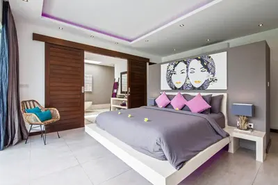a bedroom with a large bed with pink pillows at Seminyak Modern villa 4 BR fully serviced 5 in Seminyak