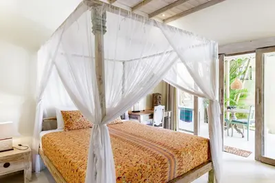 a bedroom with a bed with a canopy at Villa Aisis Seminyak in Seminyak