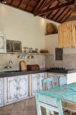 a kitchen with a counter and a table with chairs at Villa Aisis Seminyak in Seminyak