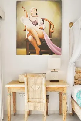 a painting of a woman sitting on a chair at Villa Aisis Seminyak in Seminyak