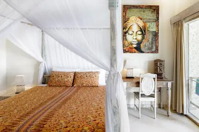 a bedroom with a canopy bed and a desk at Villa Aisis Seminyak in Seminyak