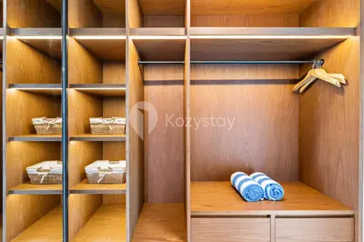 a closet with wooden shelves and blue towels at Sewana Villa by Kozystay - Natadesa Resort in Jimbaran