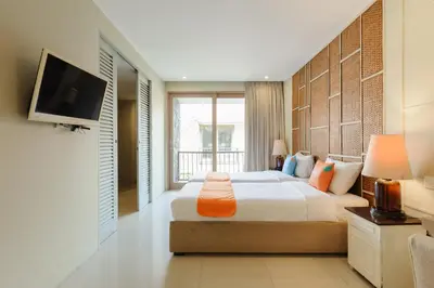 a bedroom with a bed and a flat screen tv at Sans Vibes Astana Residence Seminyak in Seminyak