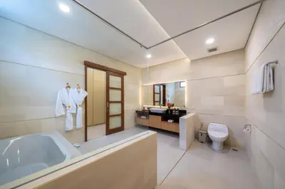 a bathroom with a tub and a toilet and a sink at Villa Ellyne Canggu by Nagisa Bali in Canggu