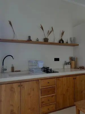 a kitchen with a sink and a counter with wooden cabinets at Shine sunset villa in Kerobokan