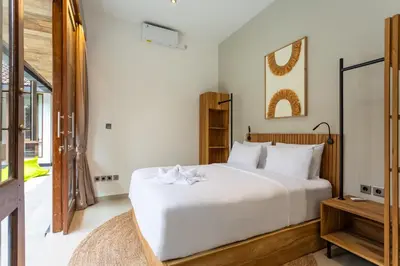 a bedroom with a white bed and a window at Villa Tropea by BaliSuperHost in Seminyak