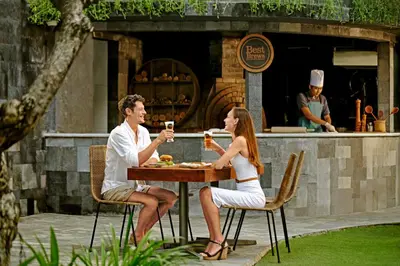 a man and woman sitting at a table with drinks at Four Points by Sheraton Bali, Kuta in Kuta