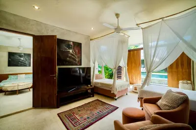a living room with a bed and a tv and a bedroom at Tropical Villa Batik - Large Garden & Pool, Concierge! 3mins to Beach, Clubs, Cafes in Seminyak