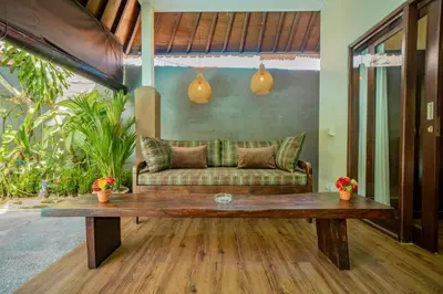 a living room with a couch and a wooden table at Villa Kiwi Seminyak in Seminyak