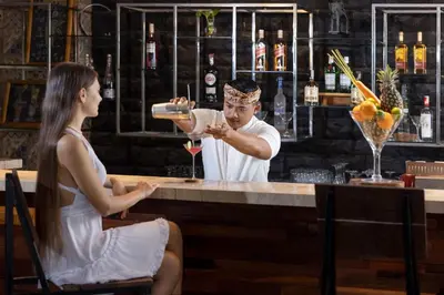 a man pouring a woman a drink at a bar at Anathera Resort Kuta Bali Airport in Kuta