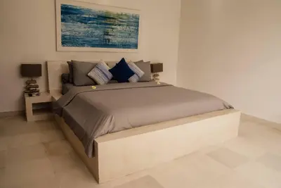 a bedroom with a large bed with blue pillows at Seminyak villa 3 chambres service 5 in Seminyak