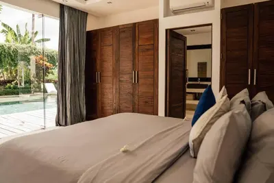 a bedroom with a large bed and a pool at Seminyak villa 3 chambres service 5 in Seminyak