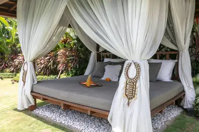a bed with a canopy with curtains and a table at Amazing 4 BR villa with garden, pool in Seminyak in Seminyak