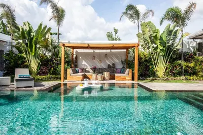 a swimming pool in a backyard with a villa at Seminyak 5 bd villa avec Chill-out extérieur in Seminyak