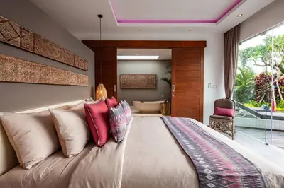 a bedroom with a large bed and a bath tub at Seminyak 5 bd villa avec Chill-out extérieur in Seminyak