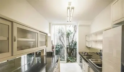 a kitchen with white cabinets and a large window at 4BR Group Holiday, Walk to Fitness, Food, Beach in Seminyak