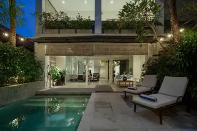 a house with a swimming pool in front of a house at 4BR Group Holiday, Walk to Fitness, Food, Beach in Seminyak