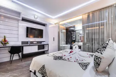a bedroom with a large bed and a kitchen at Villa Rama by JB Villas in Seminyak
