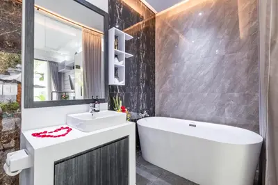 a bathroom with a white tub and a sink and a bath tub at Villa Rama by JB Villas in Seminyak