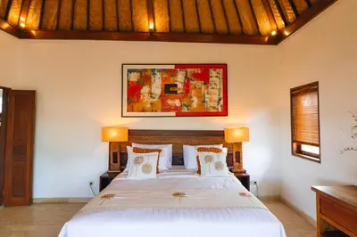 a bedroom with a large bed with two lamps at Villa Leona Seminyak in Seminyak
