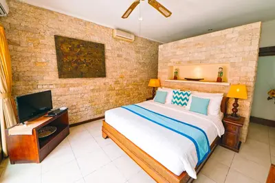 a bedroom with a bed and a flat screen tv at Villa Leona Seminyak in Seminyak