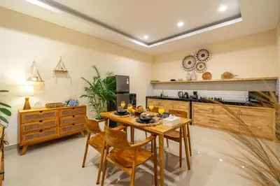 a kitchen with a wooden table and chairs and a counter at New Villa in the best area in Kuta