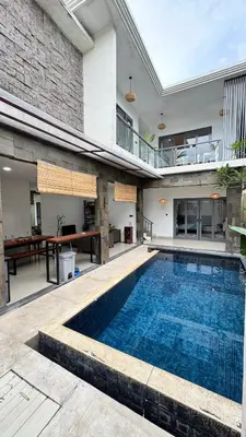 an indoor swimming pool in a house with a building at Ulun Kubu Villa in Kerobokan