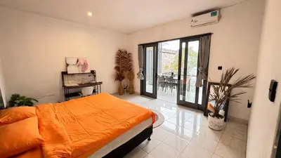 a bedroom with an orange bed and a balcony at Ulun Kubu Villa in Kerobokan