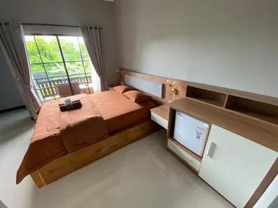 a bedroom with a large bed and a window at Semilang House in Ngurah Rai International Airport