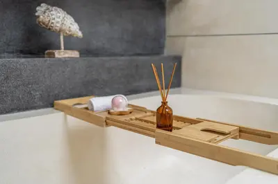 a wooden tray with a vase on a bath tub at 2min Beach, Atlas, Finns Canggu in Canggu