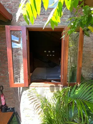a window in a brick wall with a bed in it at 1 BR Cozy Apartment in center of Seminyak in Seminyak
