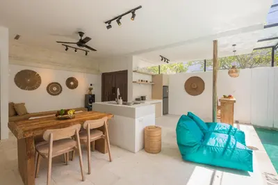 a kitchen and living room with a table and chairs at Spring Villa Nusa Dua in Nusa Dua