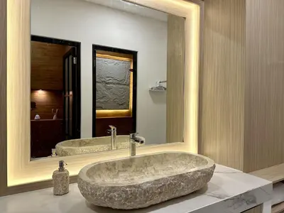 a bathroom with a large stone sink in front of a mirror at Spring Villa Nusa Dua in Nusa Dua