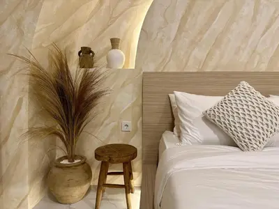 a bedroom with a bed and a table with a plant at Spring Villa Nusa Dua in Nusa Dua