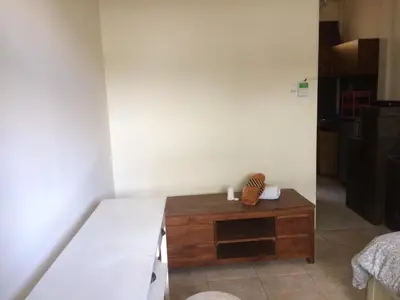 a room with a bed and a wooden table at Simple apartment 3 in Seminyak