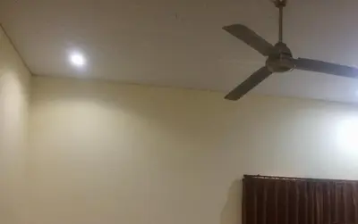 a ceiling fan in a room with a wall at Simple apartment 3 in Seminyak