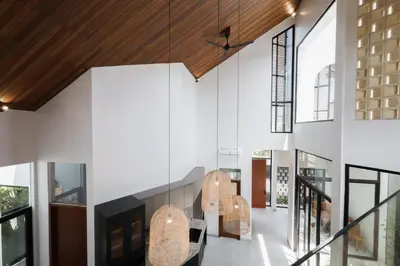 a hallway of a house with white walls and wooden ceilings at Rumah Christa in Seminyak