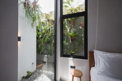 a bedroom with a window with plants in it at Rumah Christa in Seminyak