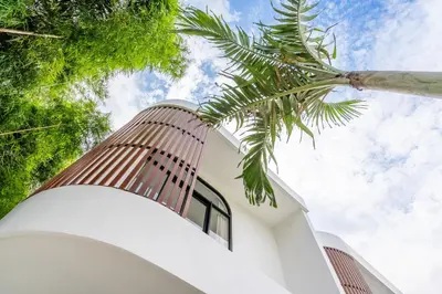 a house with a palm tree in front of it at Casa Nalani in Kerobokan