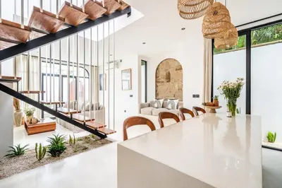 a kitchen and dining room with a large white table and chairs at Casa Nalani in Kerobokan