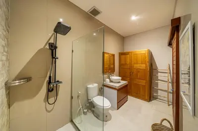 a bathroom with a shower and a toilet and a sink at Sunterra 3- Luxurious 3BR Villa in Canggu with Pool in Kerobokan
