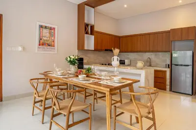 a kitchen with a wooden table and chairs at Sunterra 3- Luxurious 3BR Villa in Canggu with Pool in Kerobokan