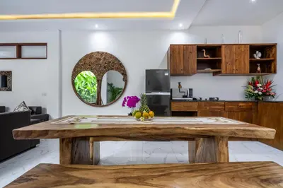 a wooden table in a kitchen with a mirror at Villa Bima by JB Villas in Seminyak