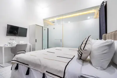 a white bedroom with a bed and a desk at Villa Bima by JB Villas in Seminyak