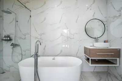 a white bathroom with a tub and a mirror at Villa Bima by JB Villas in Seminyak