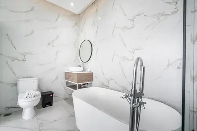 a white bathroom with a tub and a toilet at Villa Bima by JB Villas in Seminyak